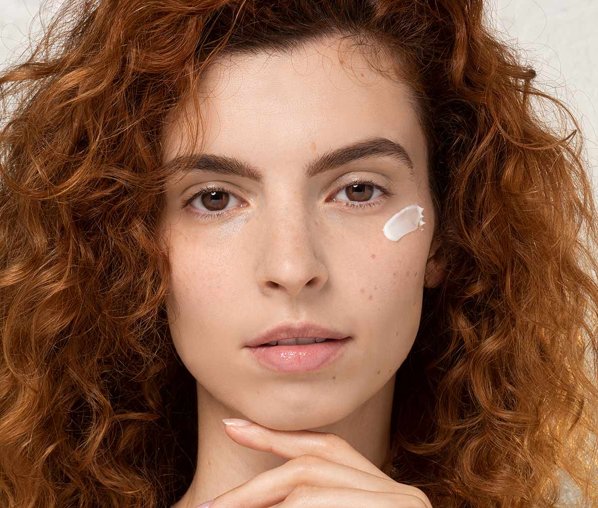 woman with eye cream moisturizer on her face