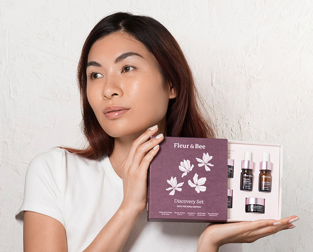 woman holding skincare gift set with 5 skincare products in deluxe mini size