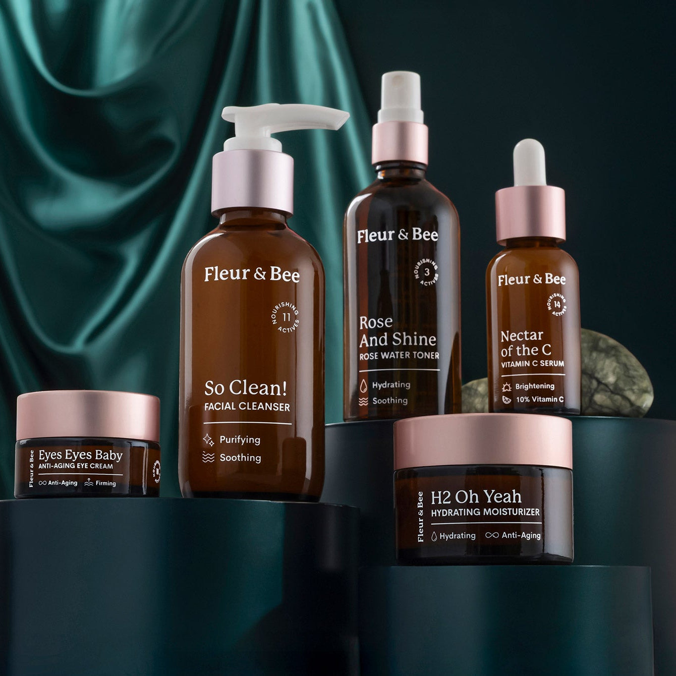 Fleur & Bee skincare products on a dark green background
