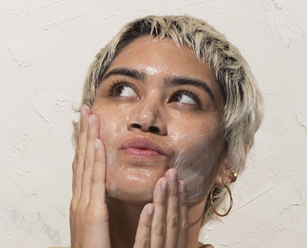 woman applying facial cleanser