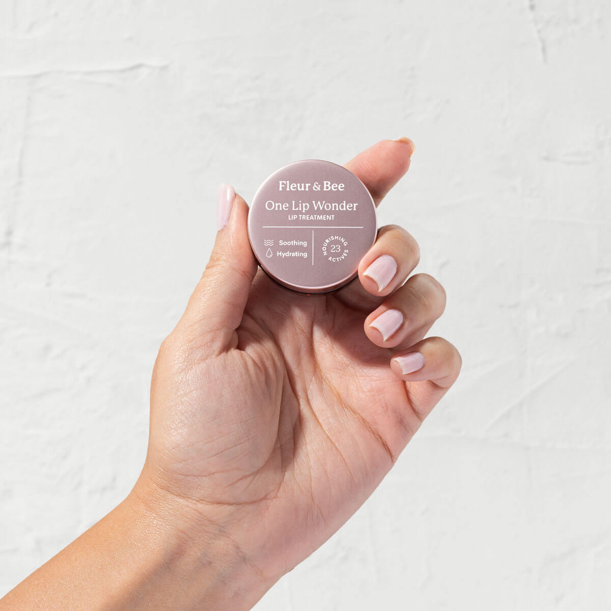 hand holding vegan lip treatment by Fleur & Bee