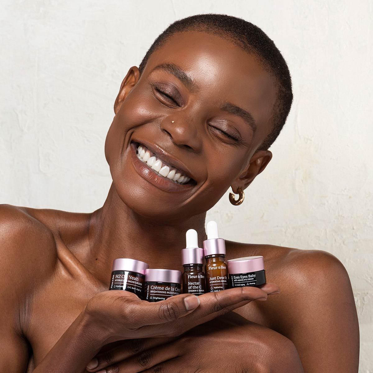 a woman holding miniature skincare products