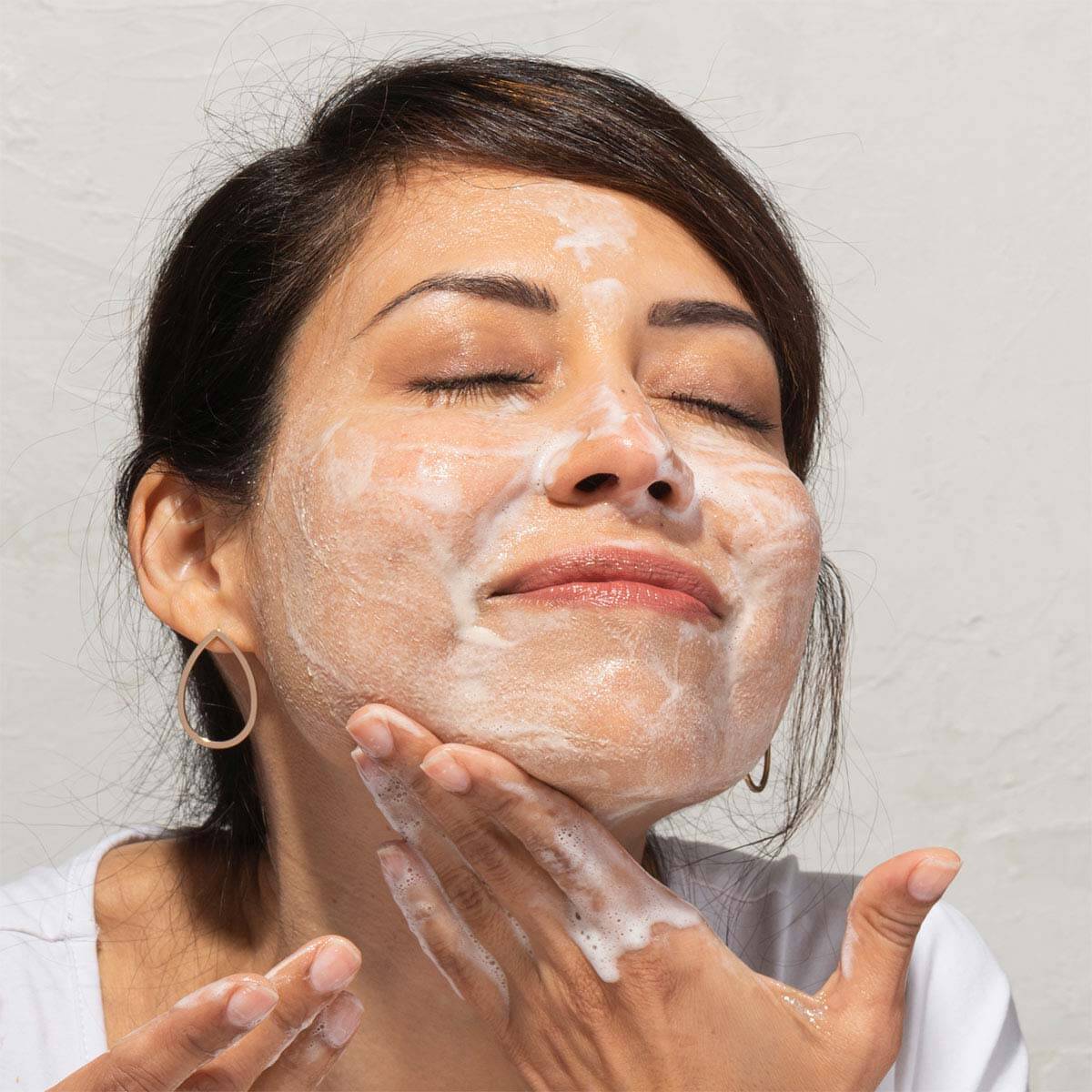 Woman using an everyday facial cleanser to clean her face